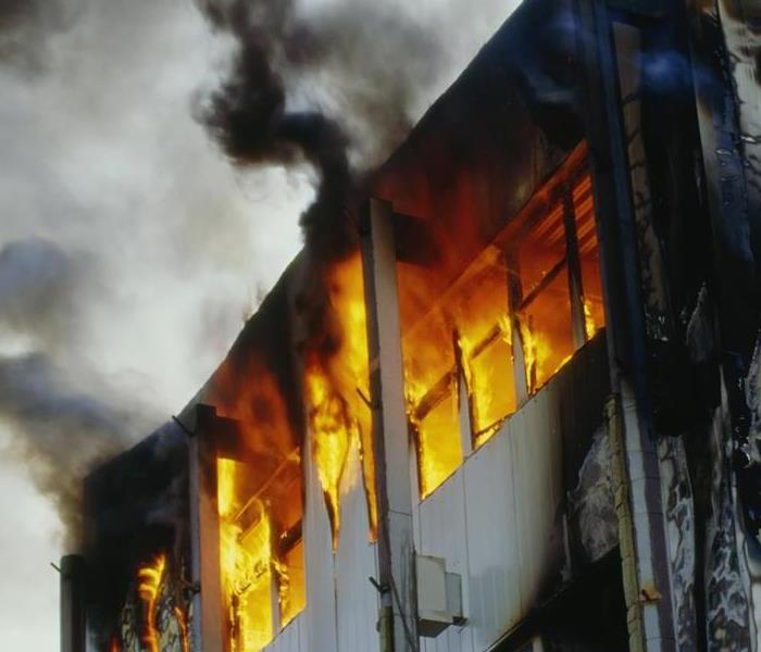 Fire blazing out of windows in a building.