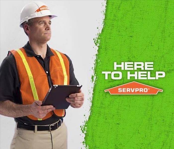 Man with clipboard and SERVPRO hard hat, and text on image that reads Here to Help